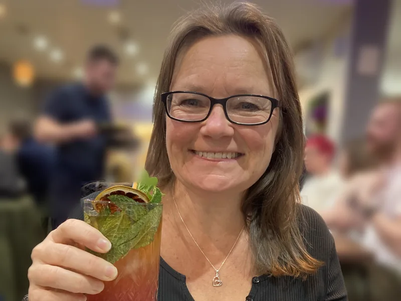 Philly smiling with a cocktail in a restaurant
